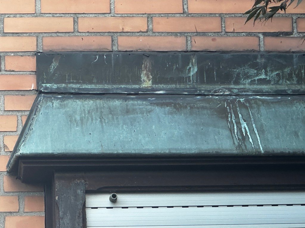 Blechabdeckung über einem Fenster mit Ablaufspuren